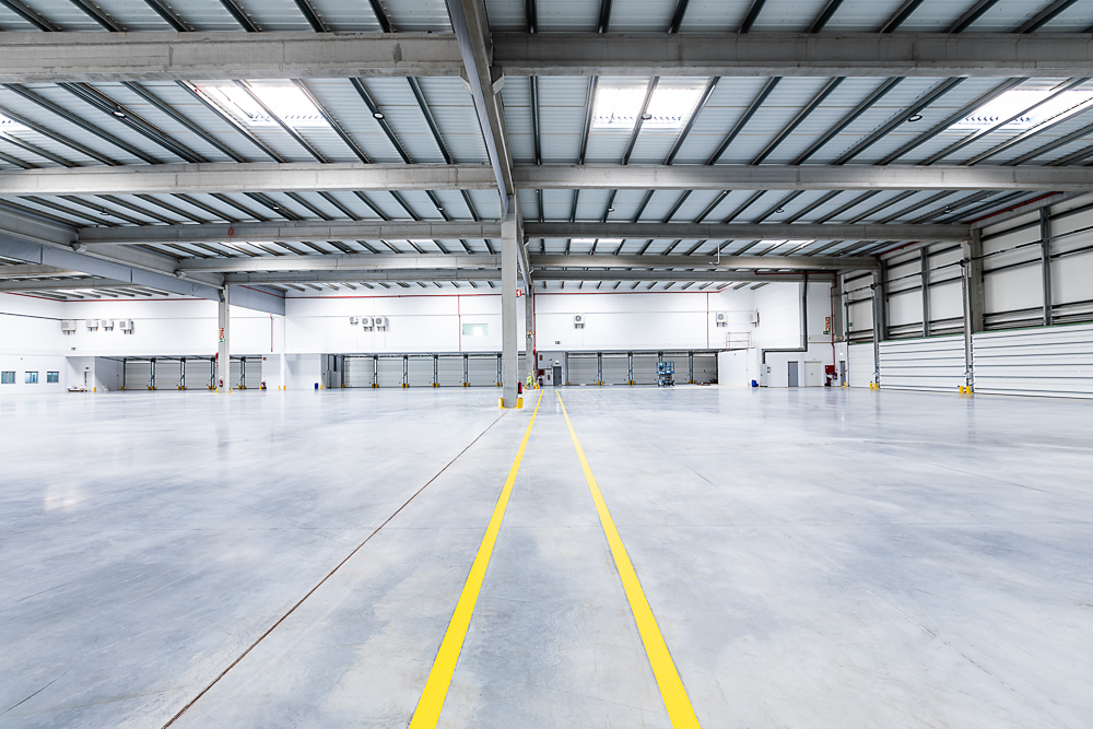Parque Logístico - Sessão fotográfica num parque logístico, capturando a amplitude dos espaços industriais e a eficiência das instalações modernas. Com uma infraestrutura robusta e funcional, o cenário reflete a dinâmica e a precisão deste ambiente.